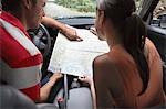 Couple observing map in car