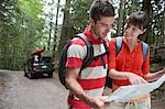 Couple observing map in forest