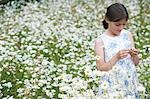 Girl (7-9) in meadow full of flowers