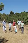Three-generation family with two children (6-11) walking in field