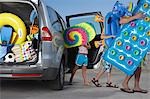 Père et ses deux enfants (6-11) déchargement beach accessoires de voiture