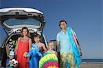 Portrait of family with three children (3-11) at beach by car