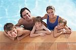 Portrait of family with three children (5-11) in swimming pool, smiling