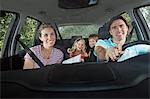 Family with two children (5-6) in car interior, portrait