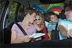 Family with two children (5-6) in car interior, talking
