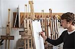 Artist drawing charcoal portrait in studio, side view