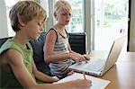 Geschwister (6-8) sitzen am Tisch, die Hausaufgaben mit laptop