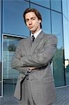 Business man standing outside office building, portrait