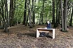Geschäftsmann, sitzen am Schreibtisch im nahen Wald denken