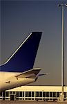 Passenger jet tailplane against airport terminal