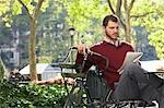 Man reading newspaper in park