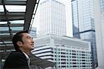 Homme d'affaires de la Chine, Hong Kong, regardant le paysage urbain, vue latérale