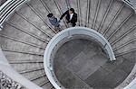 China, Hong, Kong, two business people shaking hands standing on spiral staircase, view from above