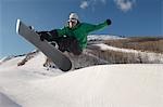 Teenage snowboarder jumping