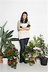 Portrait of woman surrounded by various potted plants