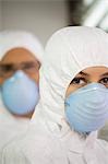 Workers in protective masks and suits, portrait, close up