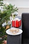 Glass of champagne and mince pies on armchair