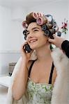 Model on Cell Phone While Having Hair Curled