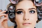 Model in Hair Curlers Applying Mascara