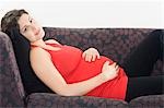 Femme enceinte détente sur le canapé, portrait