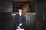 Porträt des weiblichen Reiten Reiter mit Pferd im Stall