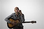 Young pensive man holding guitar