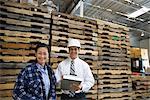 Woman and man standing in distribution warehouse, portrait