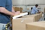 Men working in distribution warehouse, close-up
