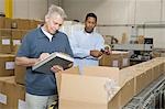 Men inspecting goods in distribution warehouse