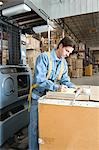 Man making notes in distribution warehouse