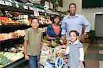 Family of four shopping in supermarket