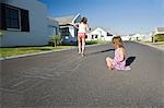 South Africa, Cape Town, two girls playing hopscotch on street