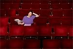 Young woman sitting in theatre stalls