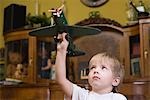 Boy playing with model airplane in home