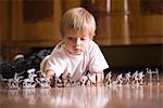 Boy playing with toy soldiers on floor