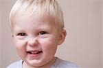 Blonde toddler scrunches his face in laughter