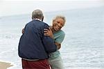 Senior couple embracing by ocean