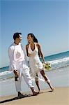 Braut und Bräutigam zu Fuß am Strand