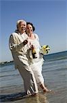 Senior mariés à pied dans l'océan