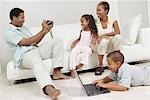 Man Videotaping Family  sitting on sofa