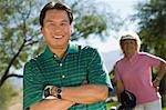 Golfer on golf course, smiling, (portrait)