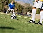 Soccer player preparing to shoot, low section