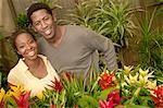 Couple among plants at nursery, (portrait)