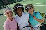 Three women on tennis court, portrait