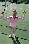Senior woman on tennis court, portrait