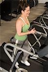 Woman Jogging on Treadmill at Health Club