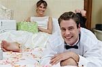 Bride and groom relaxing among presents, focus on groom