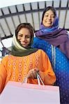 Portrait of two muslim women with shopping bags