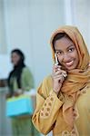 Two muslim woman, one talking on mobile phone