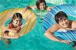 Drei Kinder in aufblasbaren Flösse in Schwimmbad, Porträt